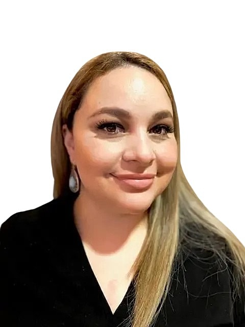 Woman with long hair and earrings smiling.