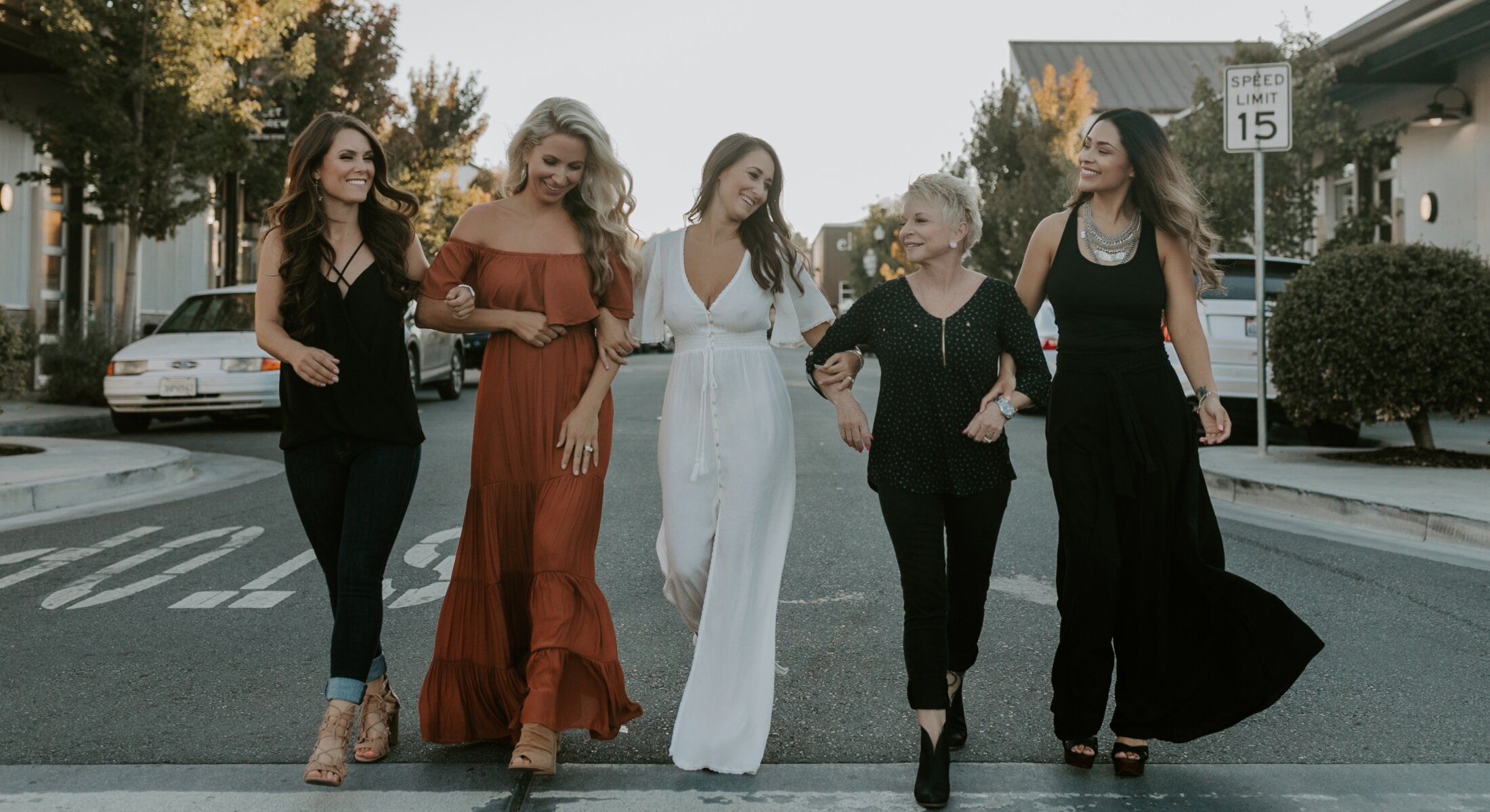 Five women walking together on a street.