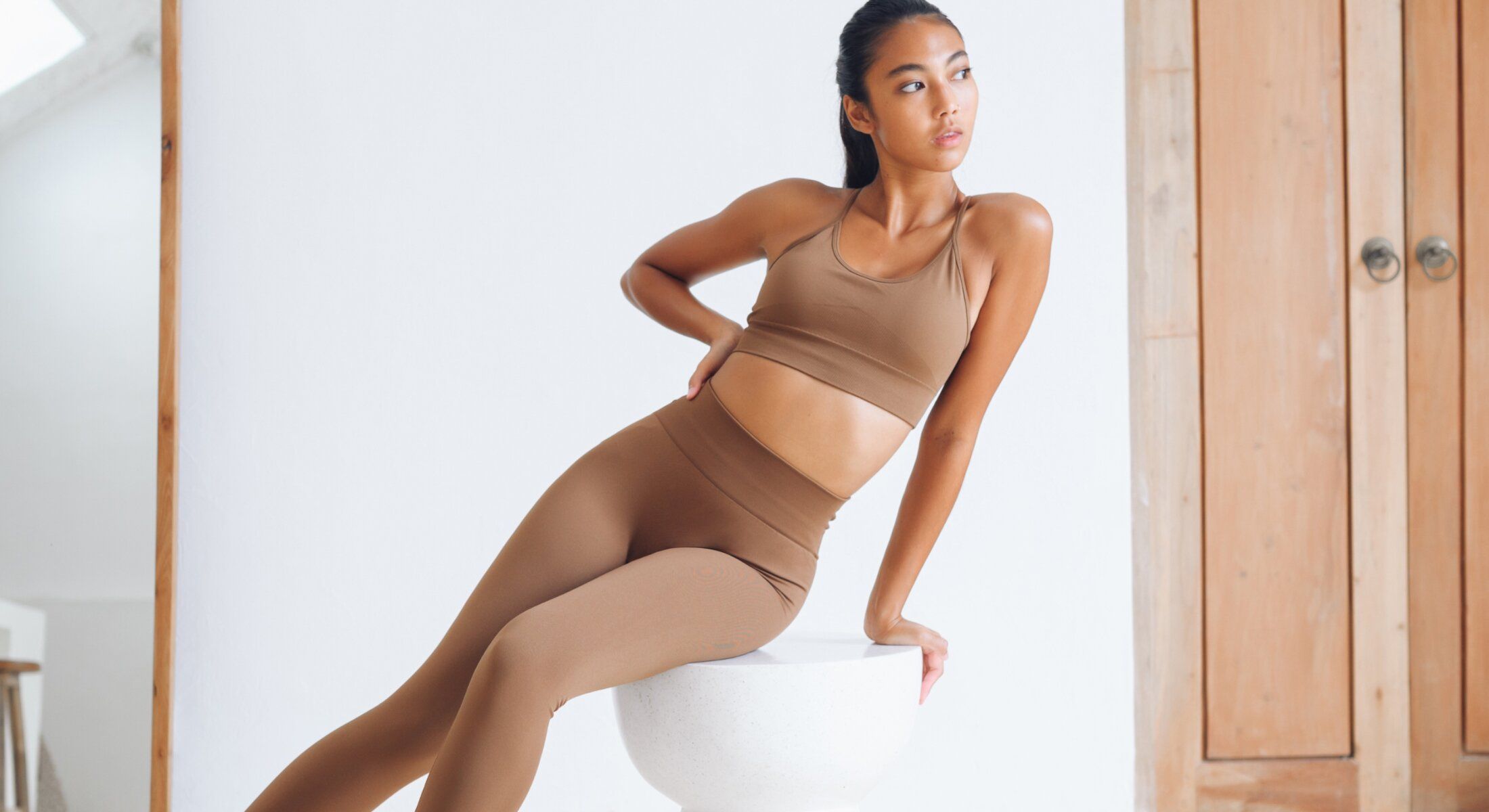 Model posing in activewear against a neutral background.